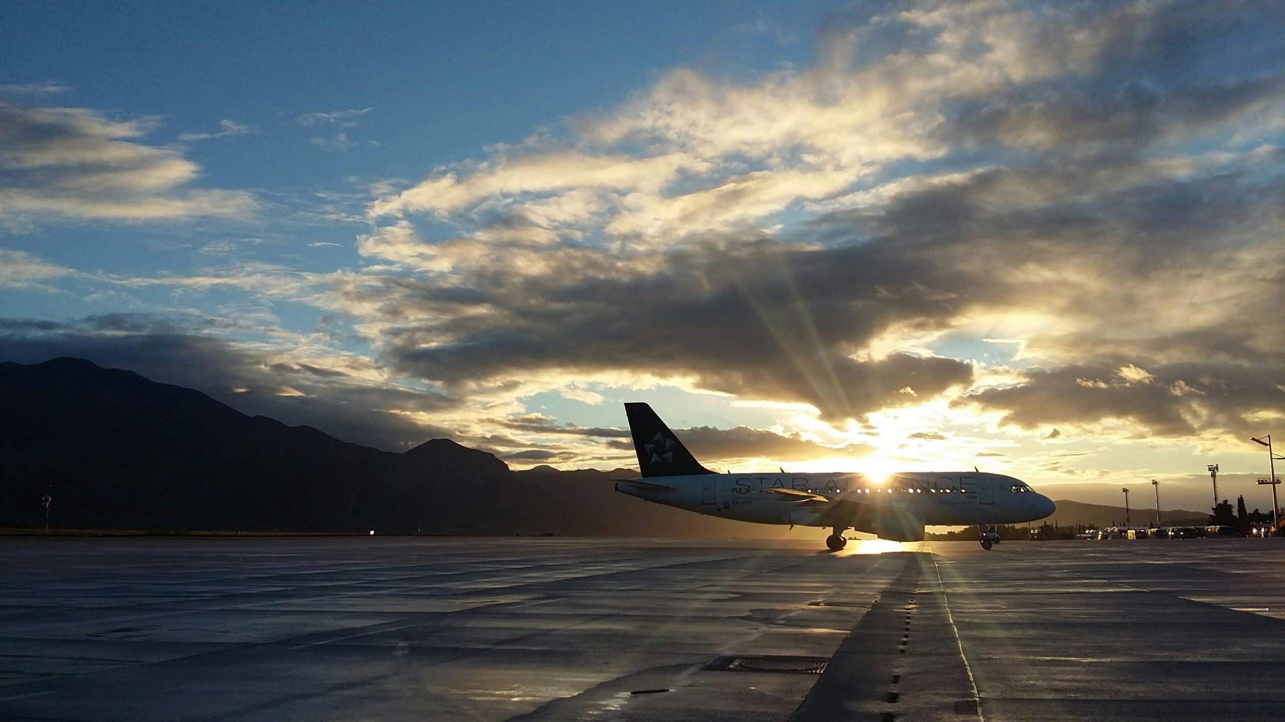 A beautiful silhouette of an airplane on a runway during a vibrant sunset at Čilipi Airport, Croatia.