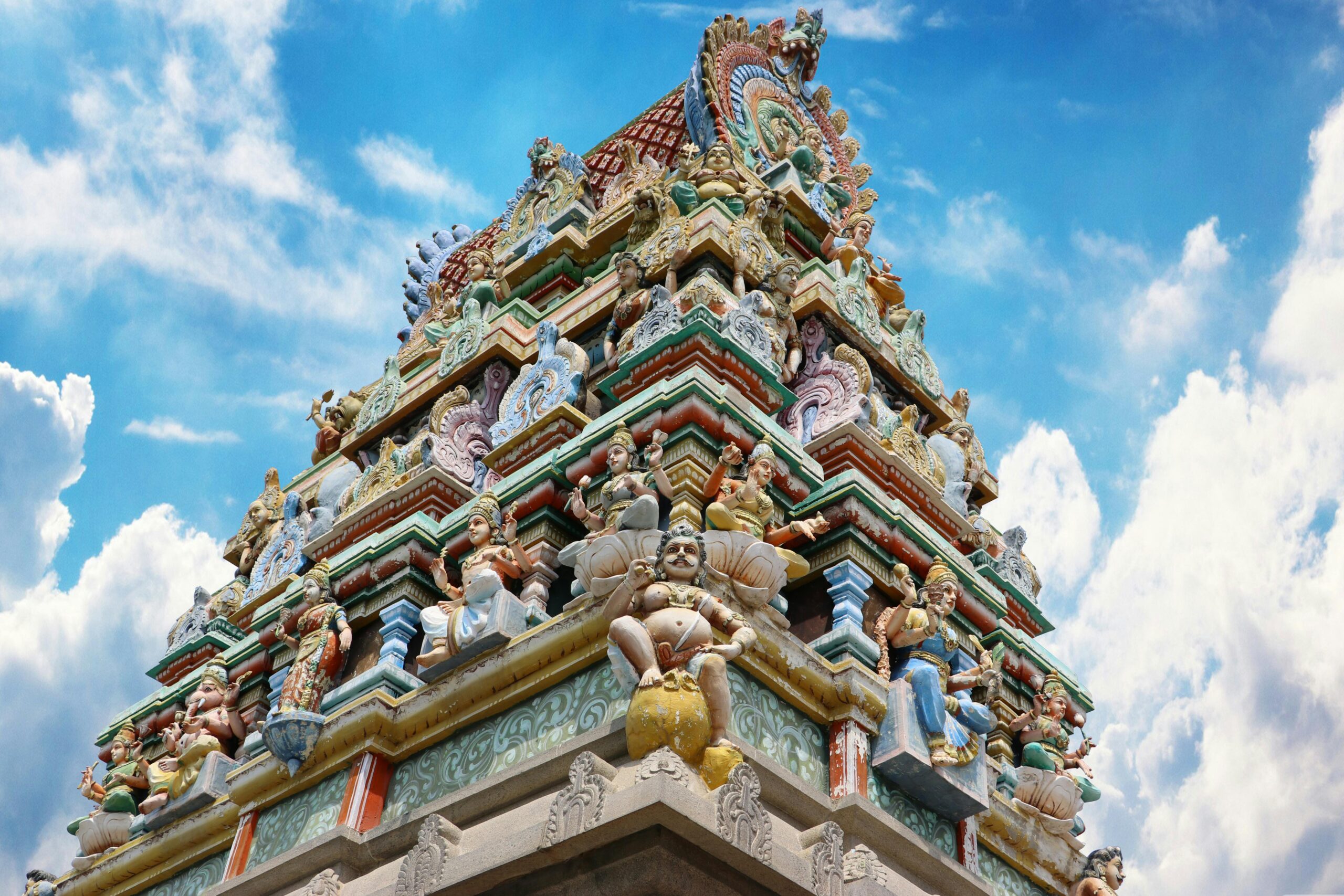 Vibrant gopuram of a Hindu temple in Salem, India, showcasing intricate designs under a blue sky.